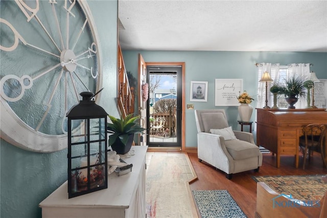 living area with hardwood / wood-style floors and a textured ceiling