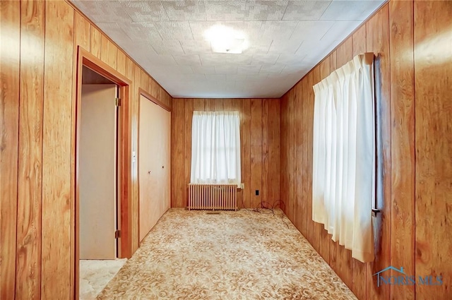 corridor with radiator heating unit and wooden walls