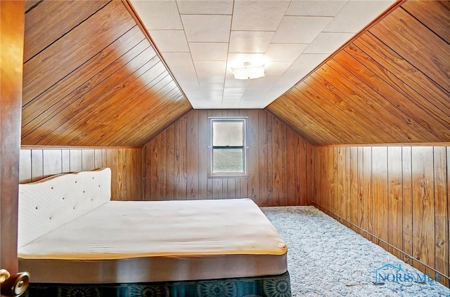 unfurnished bedroom with vaulted ceiling, carpet, and wood walls