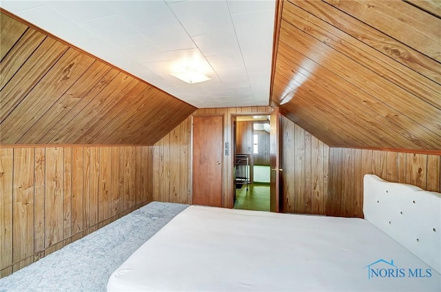 bedroom featuring lofted ceiling, wooden ceiling, and wood walls