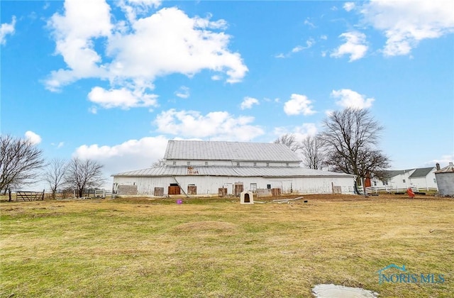 back of property with an outdoor structure and a lawn