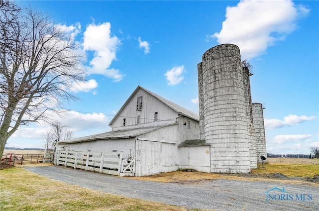 view of home's exterior with a rural view and an outbuilding