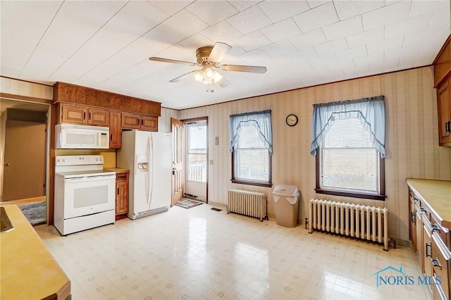 kitchen featuring crown molding, white appliances, and radiator heating unit