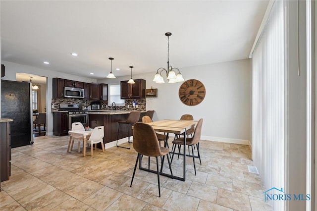 dining room with an inviting chandelier and sink