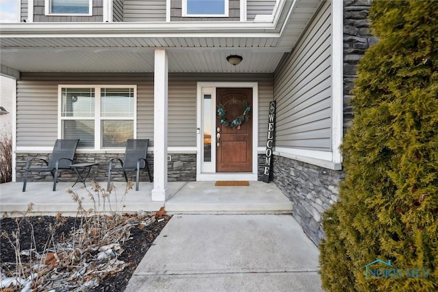 view of exterior entry featuring covered porch