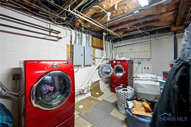 clothes washing area with washer and clothes dryer and electric panel