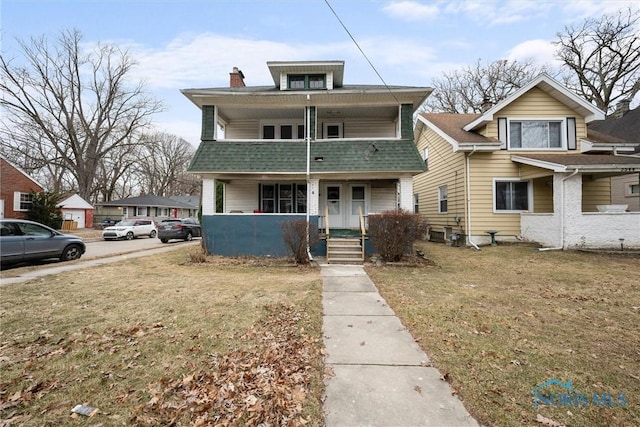 view of front of house with a balcony, covered porch, and a front lawn