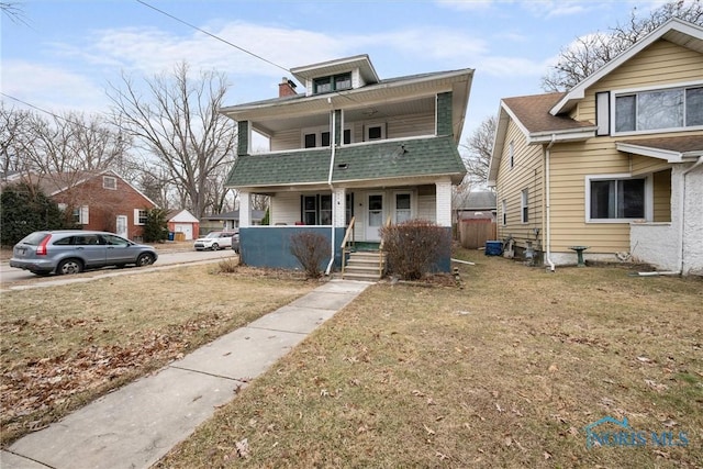 front of property with a porch, a balcony, and a front yard