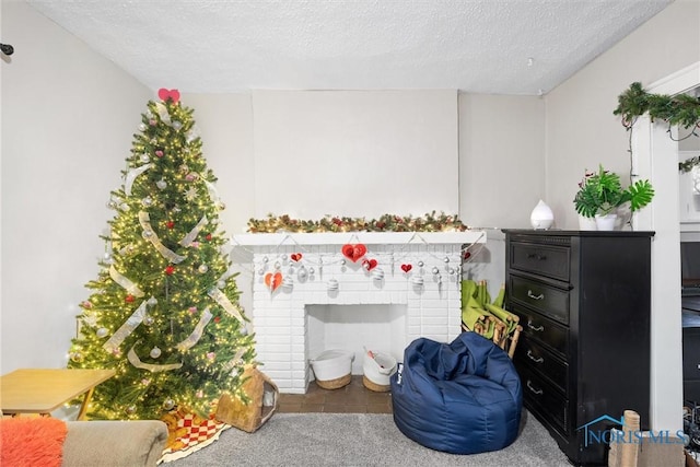 living area with a brick fireplace, carpet floors, and a textured ceiling