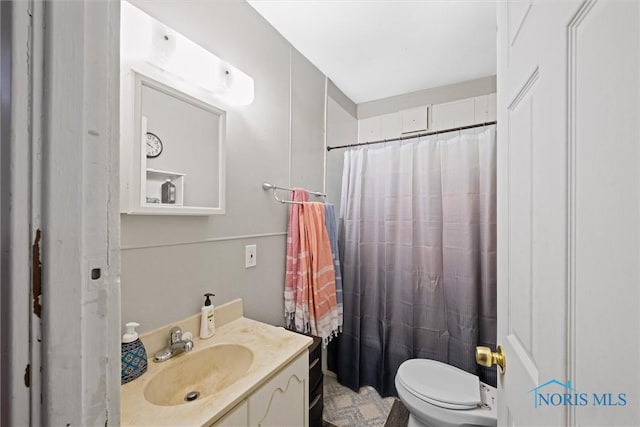 bathroom featuring vanity, walk in shower, and toilet