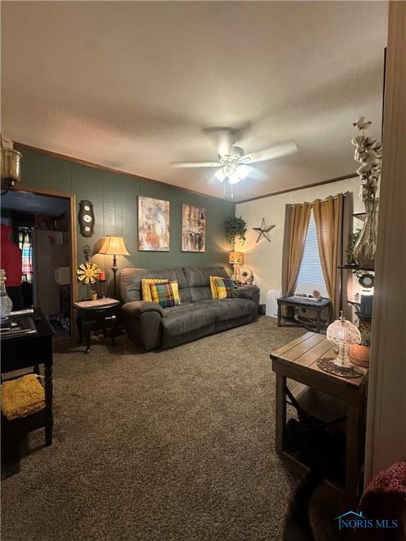 living room with ornamental molding, carpet, and ceiling fan