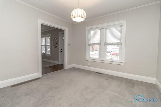 spare room featuring crown molding and light carpet