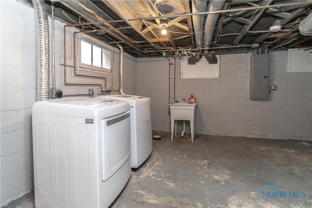 laundry room with washing machine and dryer, sink, and electric panel