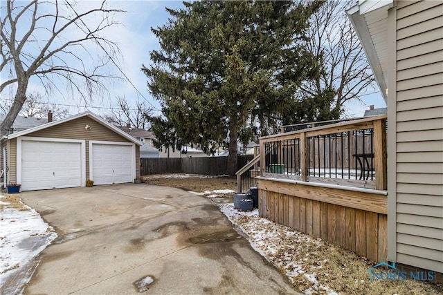 snowy yard featuring a garage and an outdoor structure