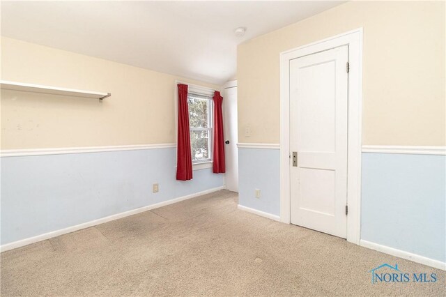 unfurnished room with vaulted ceiling and carpet floors