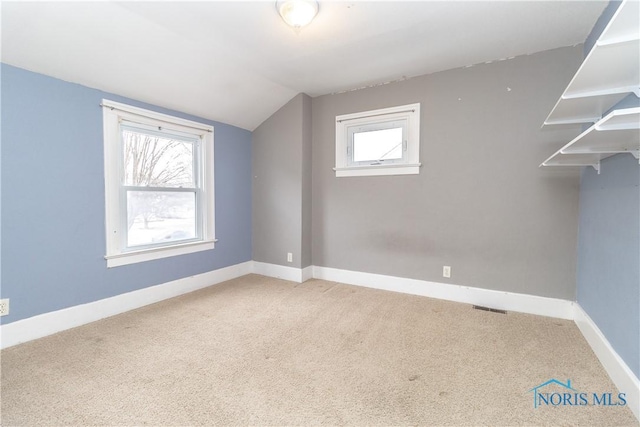 additional living space featuring lofted ceiling and carpet flooring