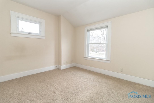 unfurnished room featuring lofted ceiling and carpet flooring