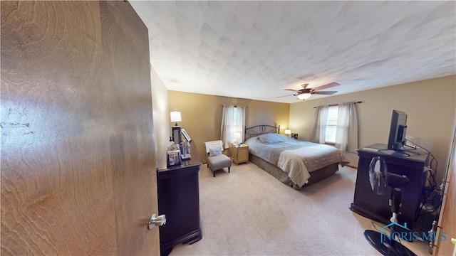 bedroom with a textured ceiling, carpet floors, and ceiling fan