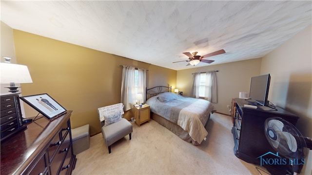 bedroom with ceiling fan and light carpet