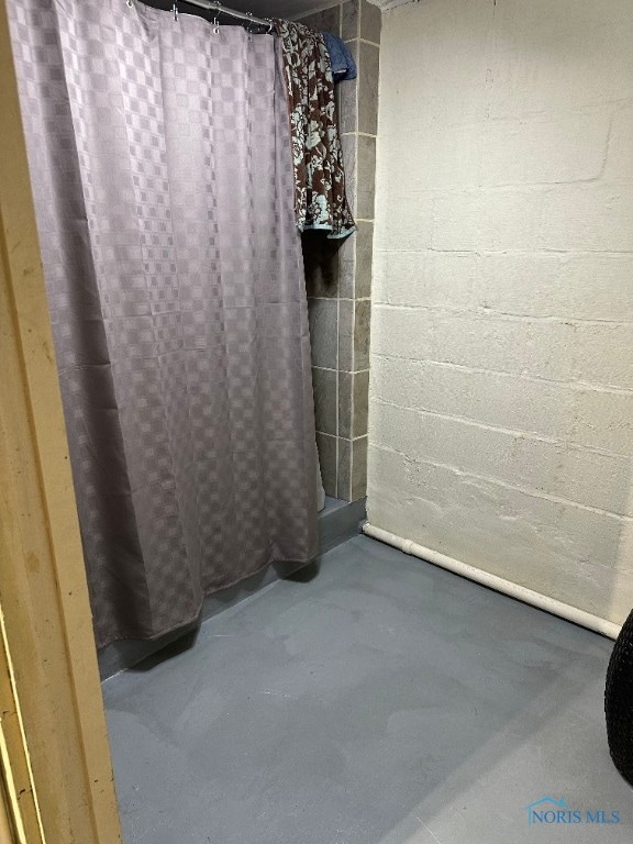 bathroom featuring concrete floors and a shower with shower curtain