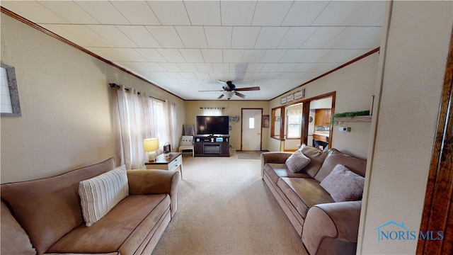 living room with light carpet, ornamental molding, and ceiling fan