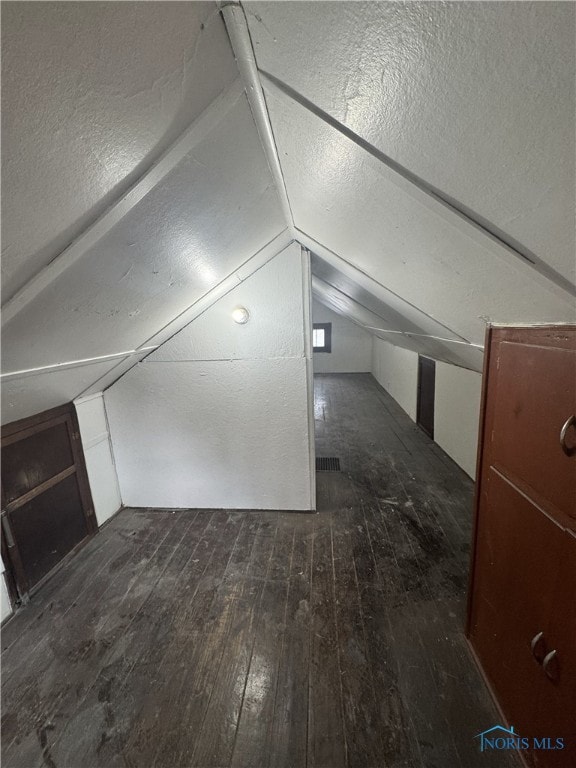 bonus room with dark hardwood / wood-style flooring and lofted ceiling