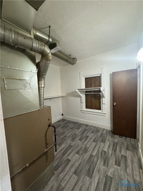 basement featuring dark hardwood / wood-style floors and a textured ceiling