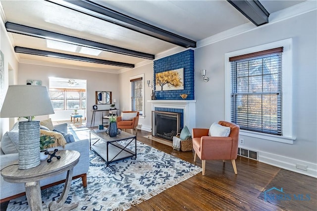 living room with dark hardwood / wood-style flooring, beam ceiling, ornamental molding, and a large fireplace