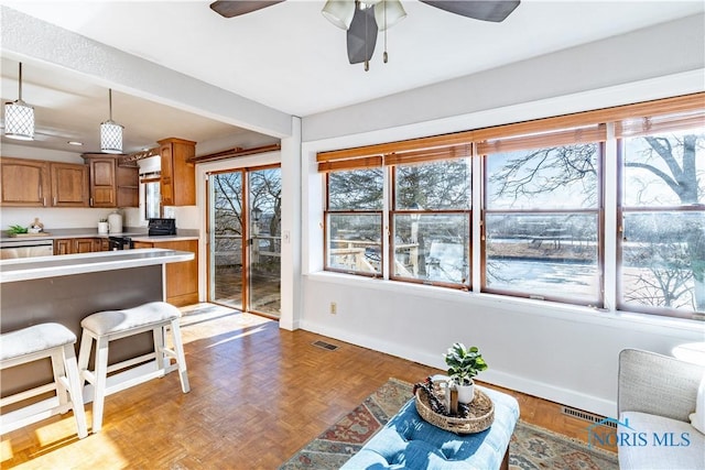 kitchen featuring dishwasher, hanging light fixtures, ceiling fan, light parquet flooring, and black electric range