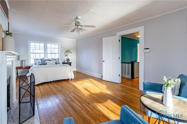 bedroom with hardwood / wood-style floors, ornamental molding, and ceiling fan