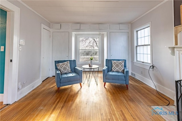 sitting room with light hardwood / wood-style flooring, crown molding, and plenty of natural light