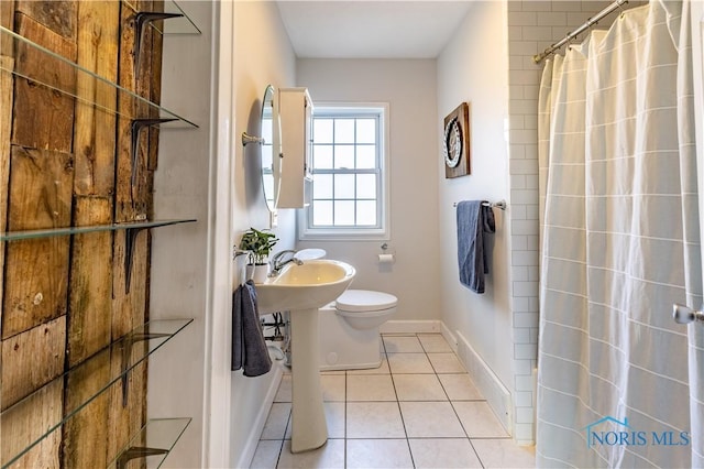 bathroom featuring toilet, tile patterned floors, and a shower with shower curtain