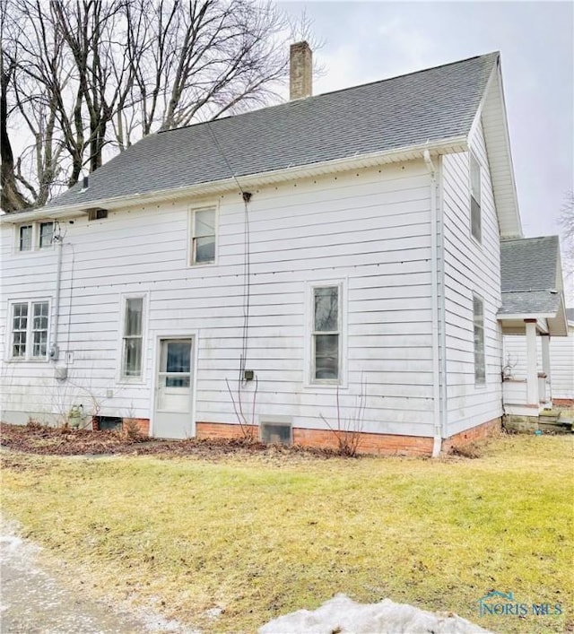 back of house with a lawn