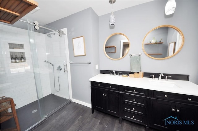 bathroom with vanity, tiled shower, and hardwood / wood-style floors