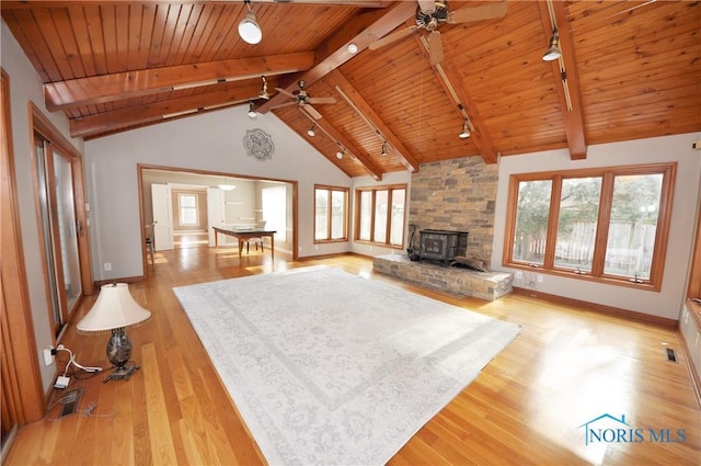 unfurnished living room featuring light hardwood / wood-style flooring, a wealth of natural light, and beamed ceiling