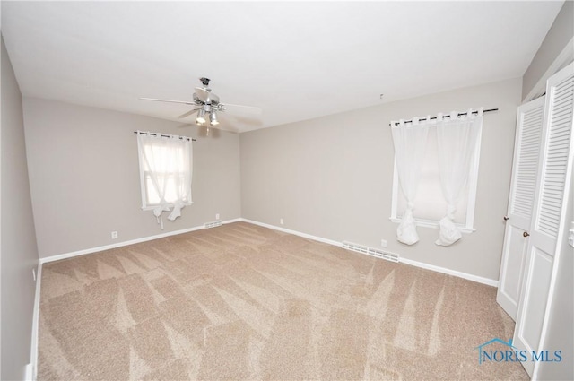 unfurnished bedroom with carpet floors, ceiling fan, and a closet