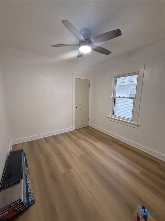 unfurnished room featuring light wood-style flooring, baseboards, and a ceiling fan