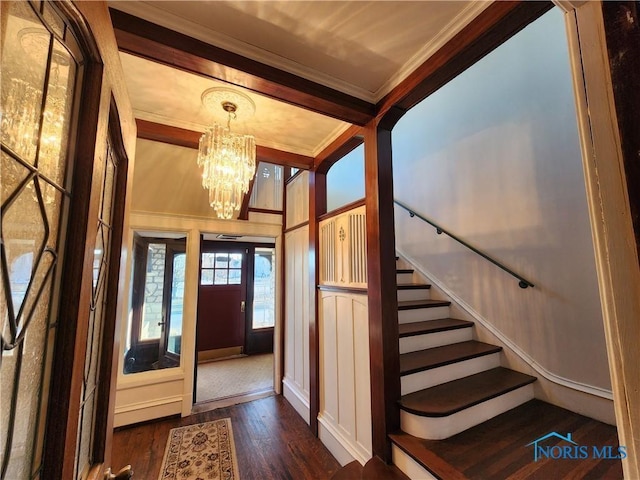 foyer entrance with a notable chandelier, crown molding, and dark hardwood / wood-style floors