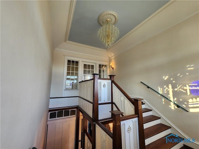 staircase featuring crown molding and a notable chandelier