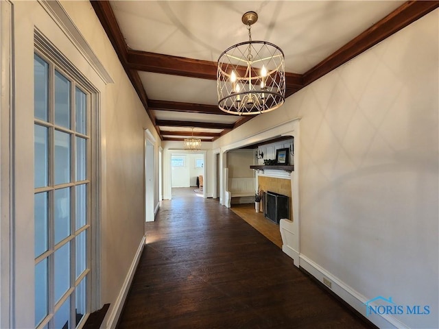 hallway featuring beam ceiling, dark wood-type flooring, and a chandelier