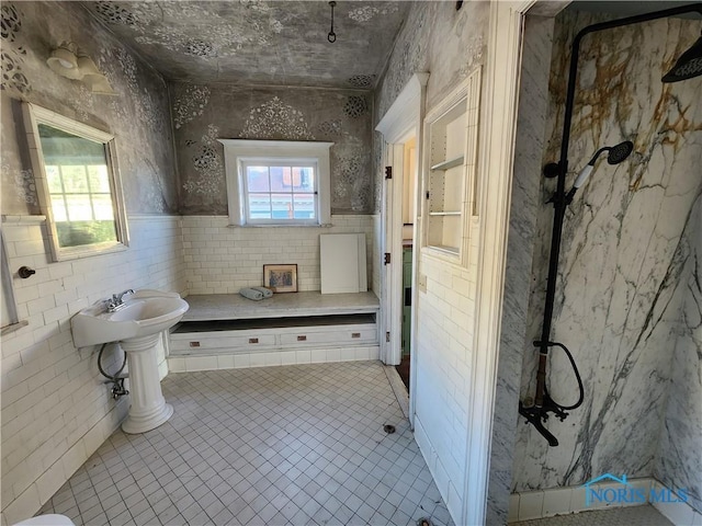 bathroom with tile walls, tile patterned floors, and a shower