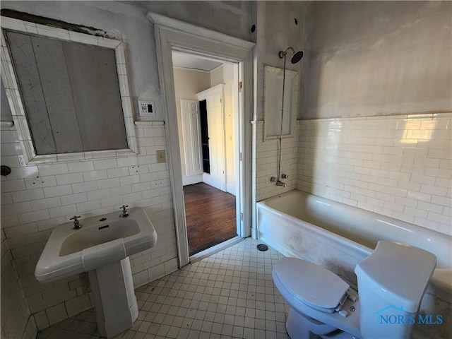 bathroom with shower / washtub combination, tile walls, tile patterned floors, and toilet