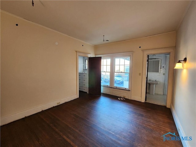 unfurnished room featuring sink, crown molding, and dark hardwood / wood-style floors