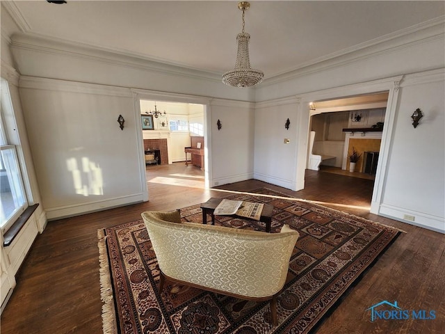 424 Winthrop St, Toledo, OH 43620 - living room featuring a chandelier, wood finished floors, ornamental molding, a fireplace, and baseboards
