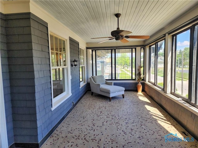 unfurnished sunroom featuring ceiling fan and wood ceiling