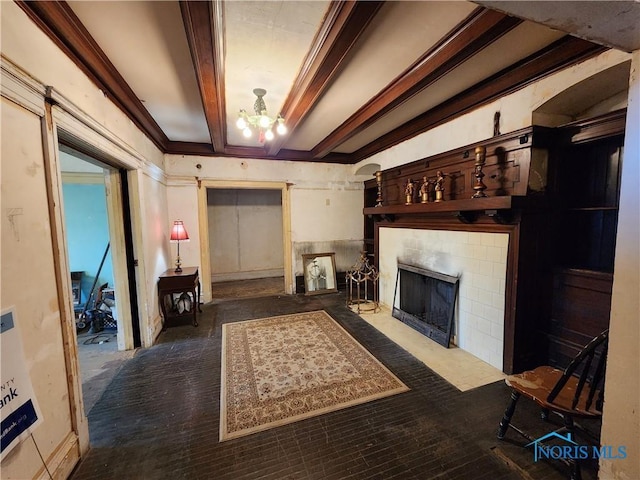 living room with a tiled fireplace, a chandelier, and beam ceiling