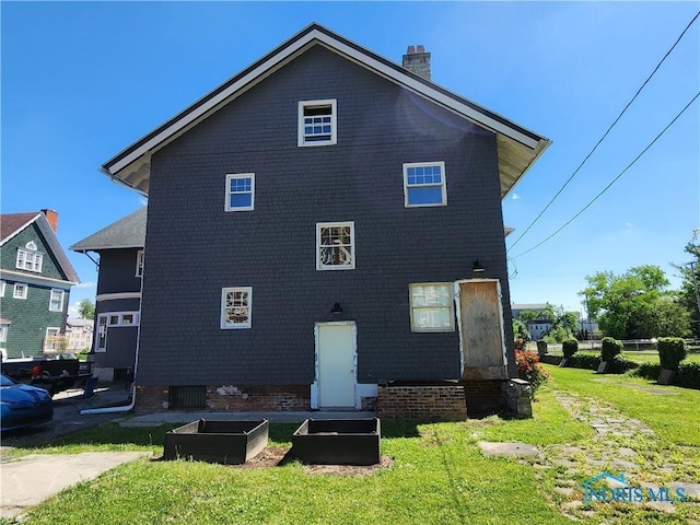 back of house with a lawn