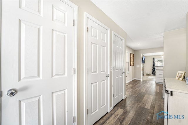 corridor featuring dark wood finished floors and baseboards