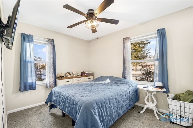 carpeted bedroom with ceiling fan, multiple windows, and baseboards