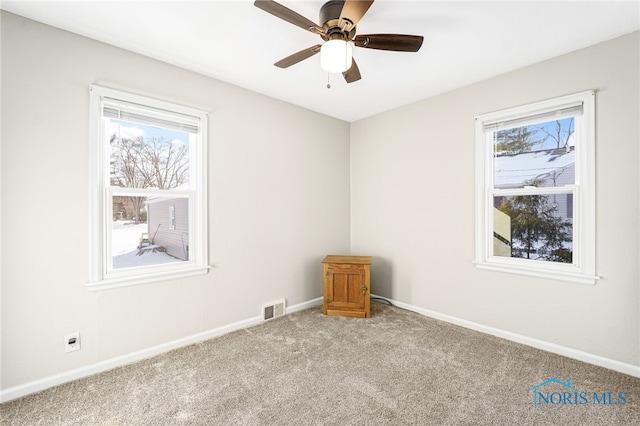 empty room with light carpet, baseboards, visible vents, and a healthy amount of sunlight